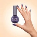 Swiss Miss Get Set Go Quick Dry Nail Enamel in shade Grape Purple 212 held by hand showing round glass bottle with shimmering deep grape purple polish and matching manicured nails.