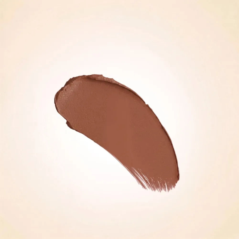 Warm medium nude brown texture swatch of Swiss Miss Cashmere Brown B-112 lipstick on a neutral background.