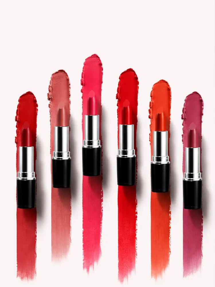 Lineup of open Swiss Miss Classic Lipstick tubes standing over matching long color swatches.