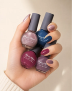 Hand holding multiple Swiss Miss Get Set Go quick dry nail enamel bottles featuring various colorful nail polish shades.