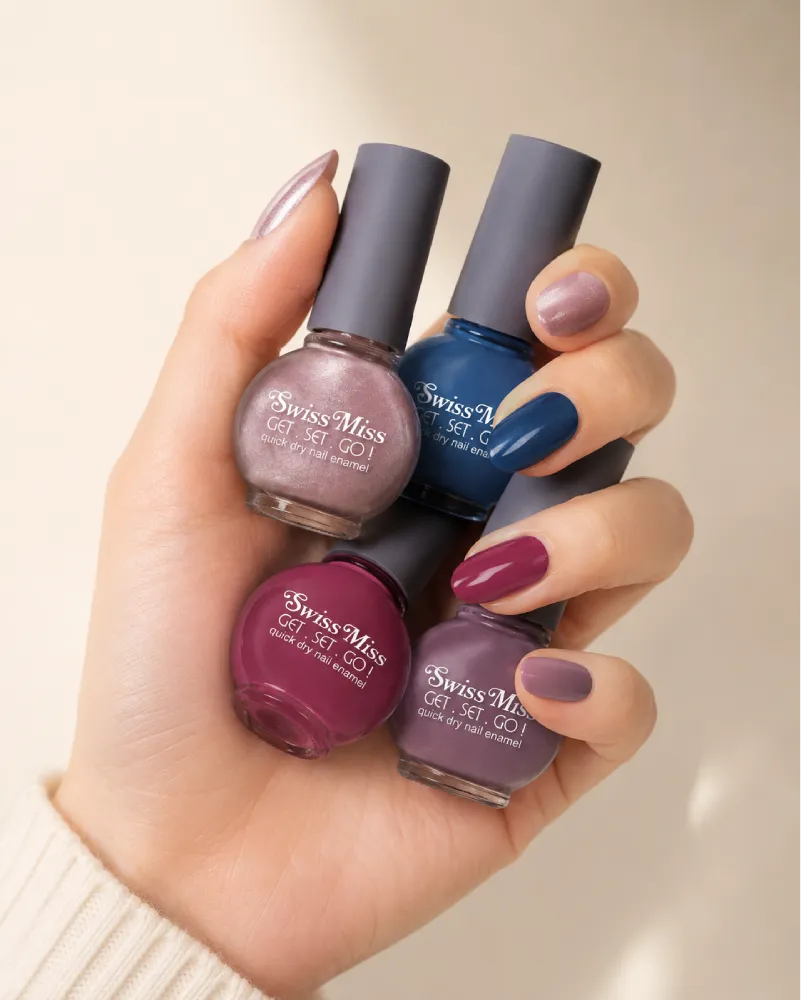 Hand holding multiple Swiss Miss Get Set Go quick dry nail enamel bottles featuring various colorful nail polish shades.