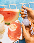 Hand holding Swiss Miss Milky White 292 Get Set Go quick dry nail enamel bottle displaying soft off-white pastel polish applied on long nails.