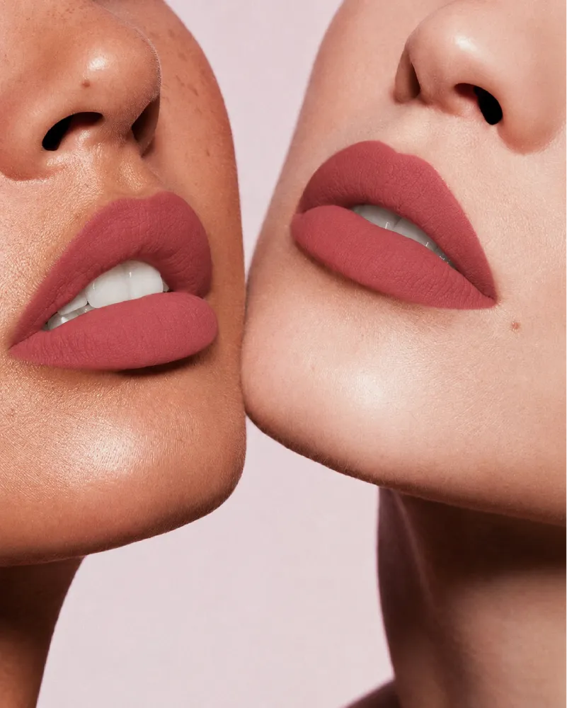 Close-up shot of two models with different skin tones wearing Swiss Miss Silk Lipstick in shade Candy Crush (716).