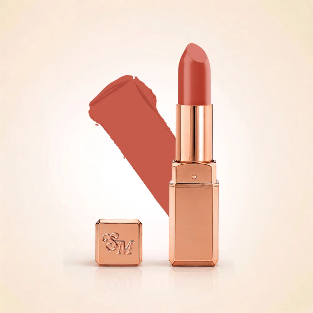 Swiss Miss Silk Lipstick in shade Clay Crush (704) in gold bullet packaging shown alongside a textured cream color swatch.