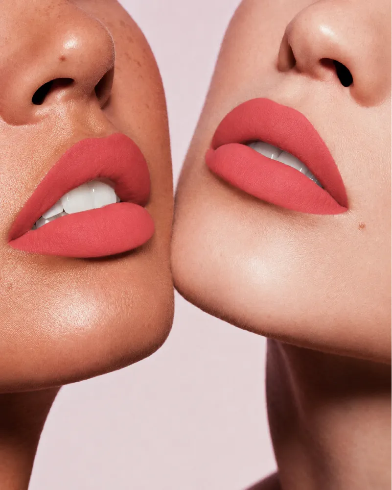 Close-up shot of two models with different skin tones wearing Swiss Miss Silk Lipstick in shade Dusky Rose (701).