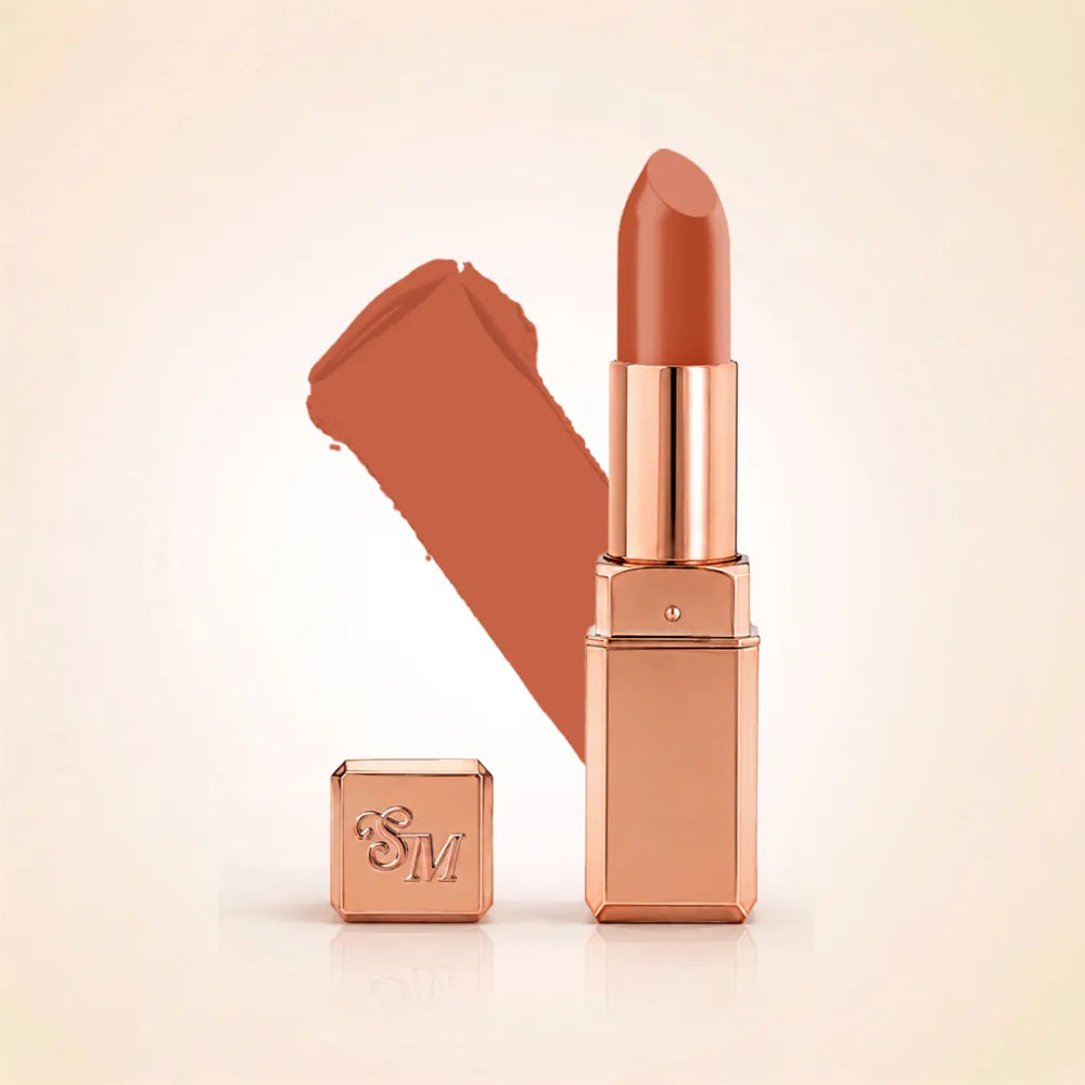 Swiss Miss Silk Lipstick in shade Glitter Bomb (729) in gold bullet packaging shown alongside a textured cream color swatch.