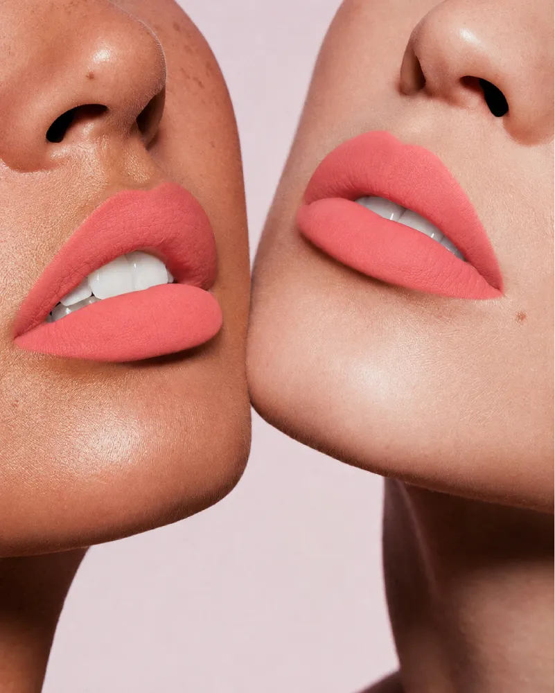Close-up shot of two models with different skin tones demonstrating Swiss Miss Silk Lipstick in shade Honey Pink (702).