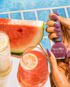 Hand holding Swiss Miss True Pink 271 Get Set Go quick dry nail enamel bottle displaying dusty mauvey pink polish applied on long nails.